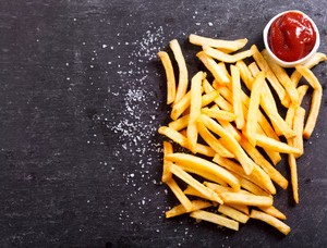 French fries with ketchup on dark table, top view